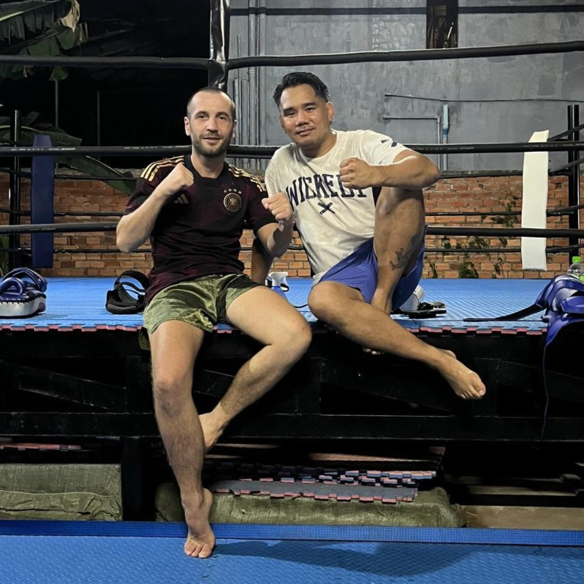 Kevin and Albert sitting together on the edge of the ring.