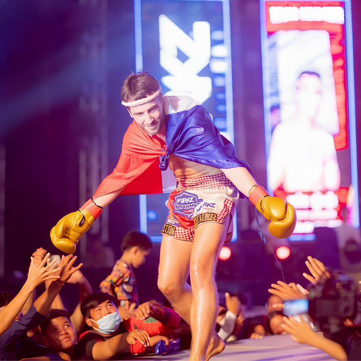 Kevin wearing boxing gloves and the French flag while greeting spectators after a fight.